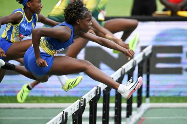 Hydel High School’s Keeneeisha Robinson clears a hurdle during th girls’ ClassFour 70-metre hurdles final.