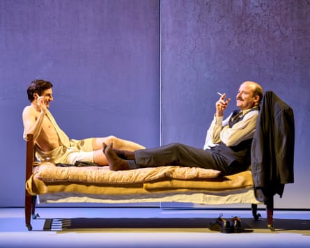 The two actors reclined at opposite ends of a bed on stage, smoking cigarettes