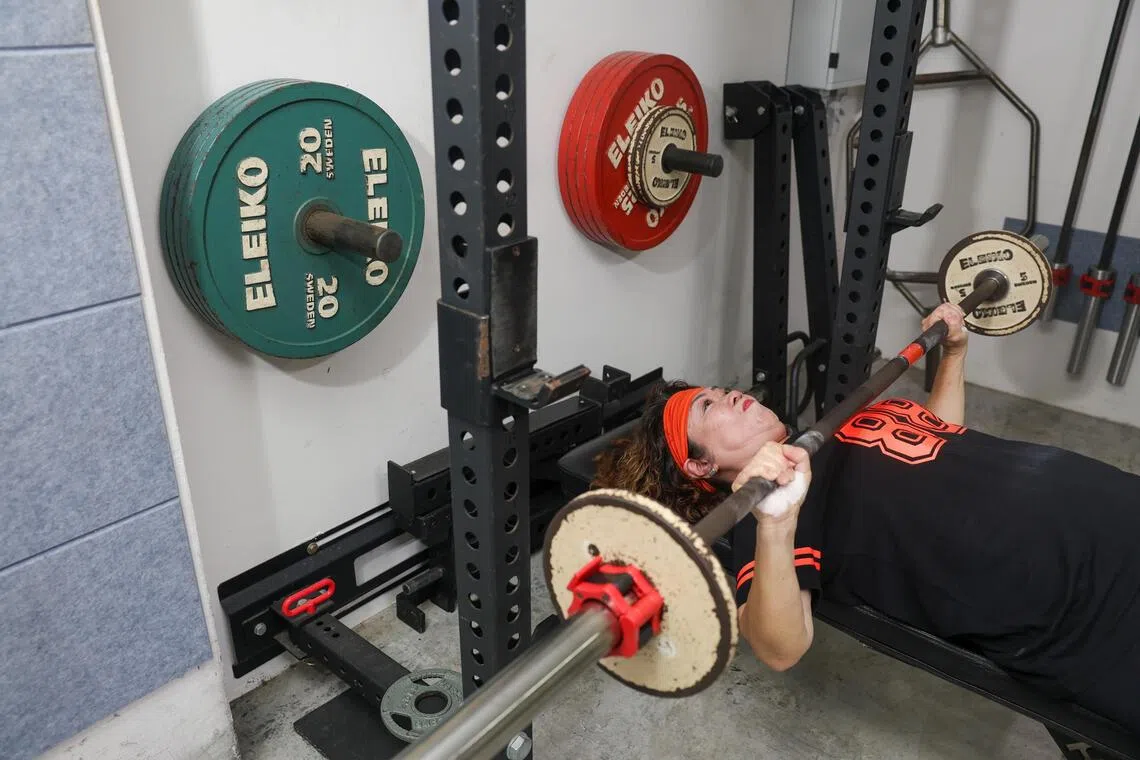 71-year-old Lim Lean Ee performing a bench press during her training session at Stoic Strength Gym on Sept 16.